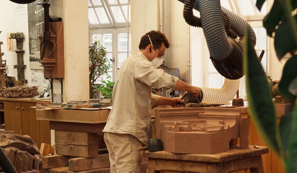 Tailleur de pierre entrain d'ajuster son poste au centre des ateliers de la fondation Oeuvre Notre Dame de Strasbourg.