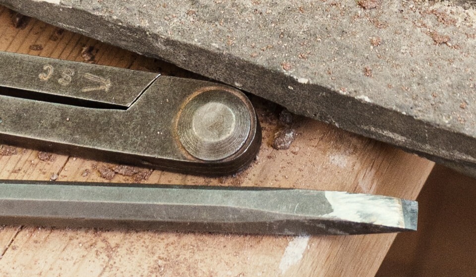 Plan serré sur des outils posé sur une table en bois.